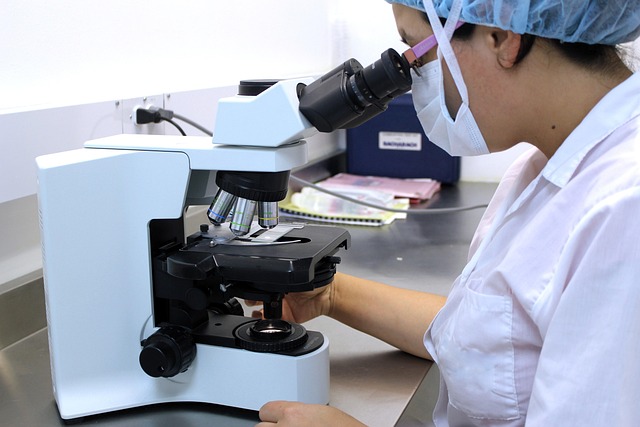 researcher looking through a microscope