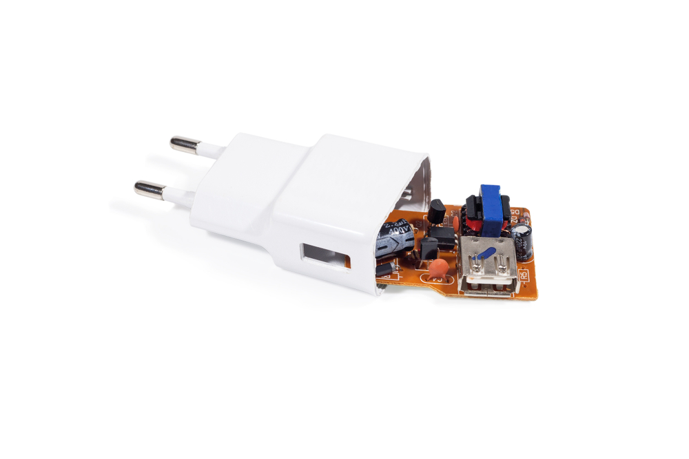 Broken charger in white color. Close-up. Isolated on white background.
