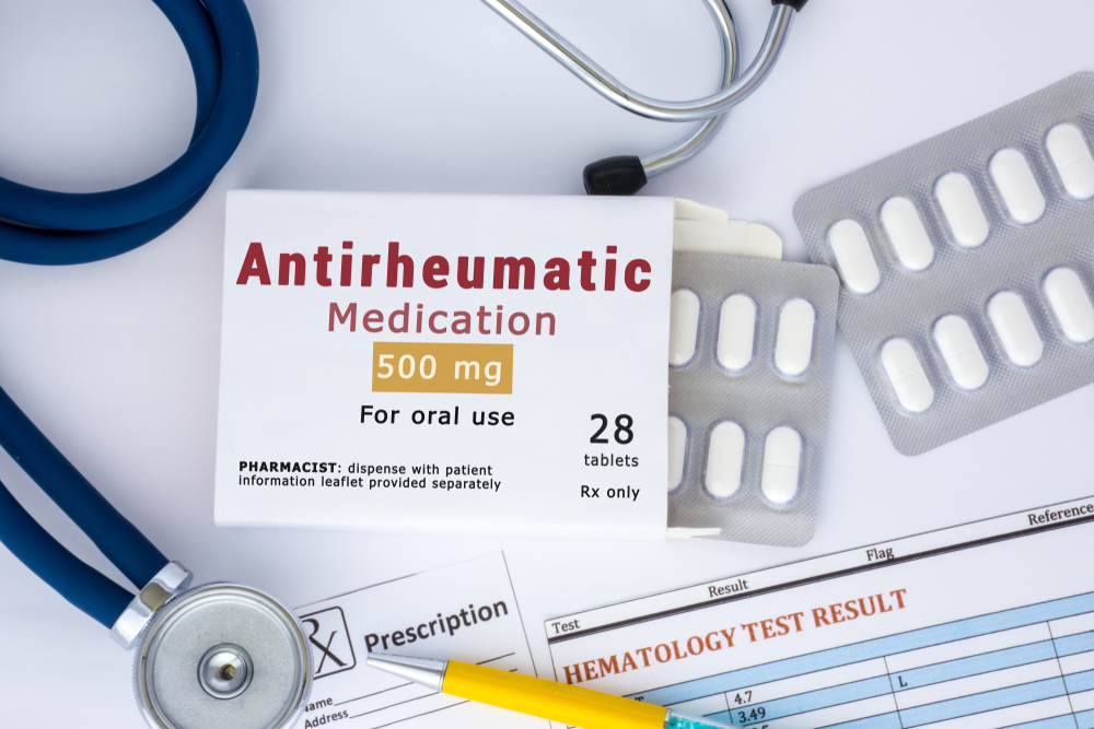 KYIV, UKRAINE-APRIL 22, 2019: Antirheumatic medication or drug concept photo. On doctor table lies open packaging labeled "Antirheumatic medication" and fell out of her blisters with pills treatment