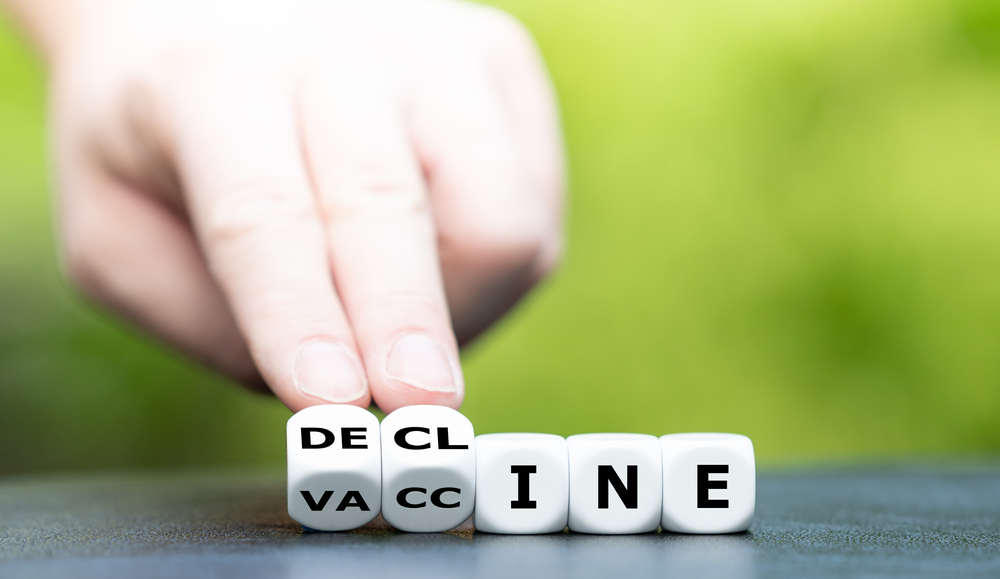 Symbol for declining vaccinations. Hand turns dice and changes the word vaccine to decline.
