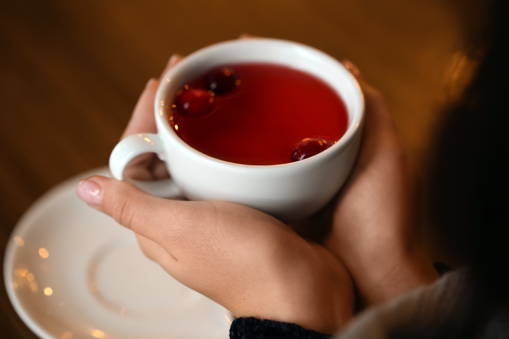 Young woman drinking tea at table in cafe
