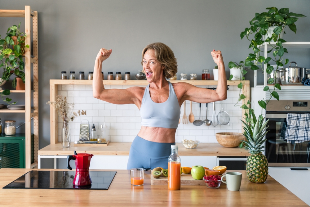 Beautiful mature senior woman at home, domestic life and leisure moments - 50-60 years old pretty female adult wearing sportswear eating healthy food after fitness workout
