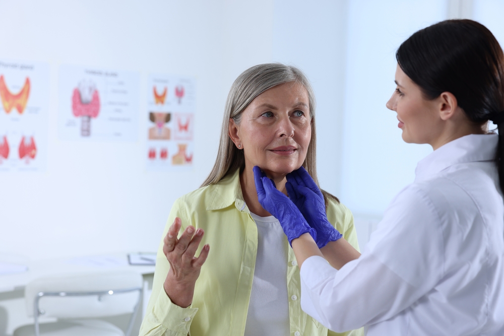Endocrinologist examining thyroid gland of patient at hospital
