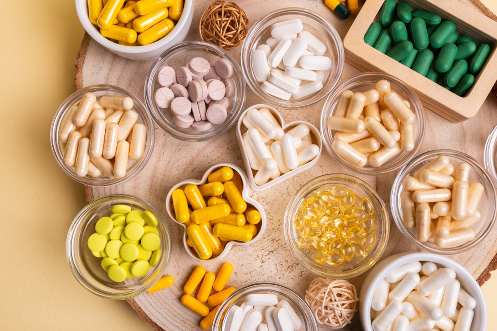 Different nutritional supplements, minerals and vitamins such as vitamin d3 softgels capsules, vitamin C, B, A, magnesium, lactase capsules, zinc, calcium, probiotics in jars to make better health.