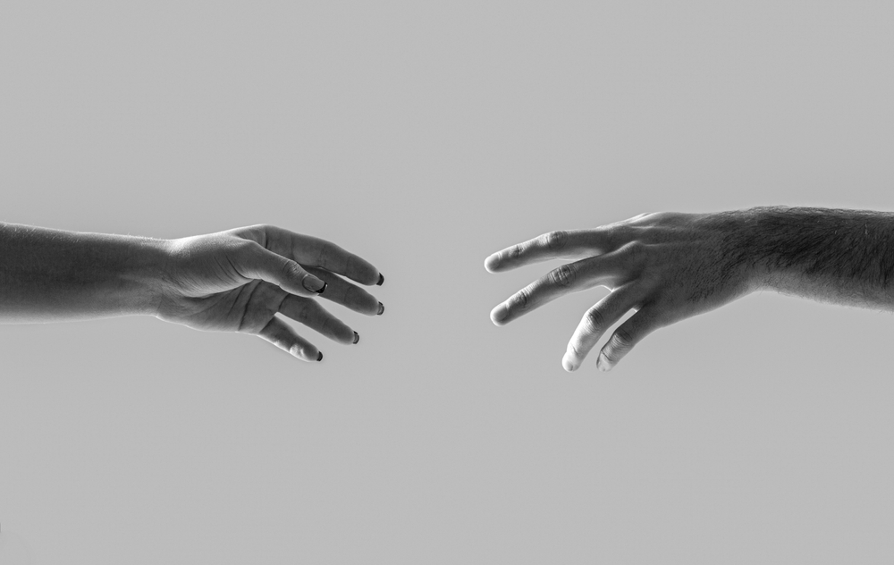 Hands man, woman reaching to each other, support. Hands of male and female holding together. Girl and man holding hands together. Giving a helping hand to another. Woman and man hand. Black and white.