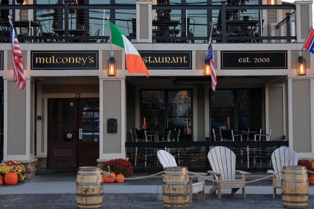 Fairport, NY, USA - November 8th 2024 - Storefront of Mulconry's Irish Pub and Restaurant in Upstate New York. Sunrise light illuminates the pub and surroundings as the holiday season approaches.
