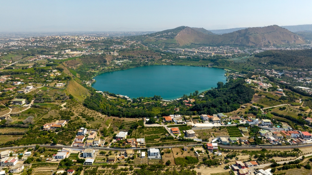 Aerial view of Lake Avernus (Lago d'Averno) located Pozzuoli, near Naples, in Campania, Italy. It is a volcanic crater lake located in Phlegraean Fields (Campi Flegrei). The lake is roughly circular.