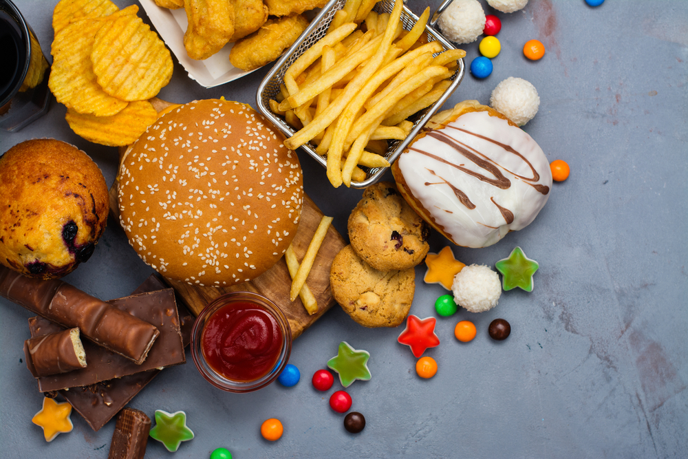 Assortment of unhealthy products that's bad for figure, skin, heart and teeth. Fast carbohydrates food. Space for text
