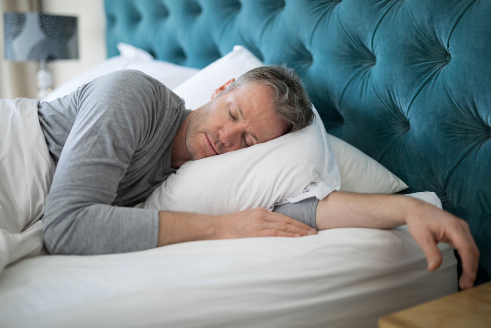 Man sleeping on bed in bedroom at home
