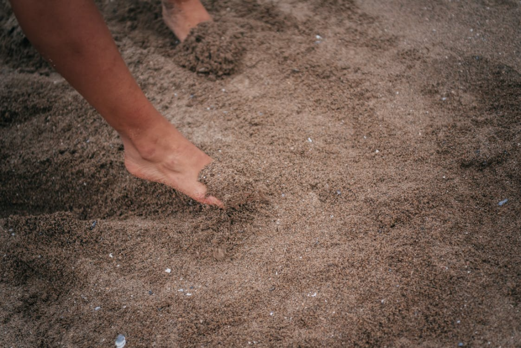 Persons Foot on Brown Sand
