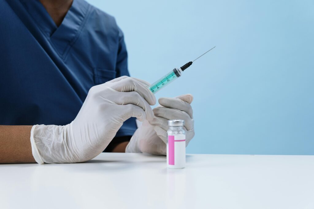 Person Wearing Gloves Holding Syringe

