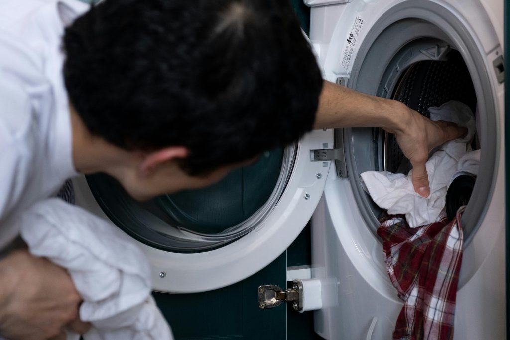 Man Taking Laundry out of the Washing Machine

