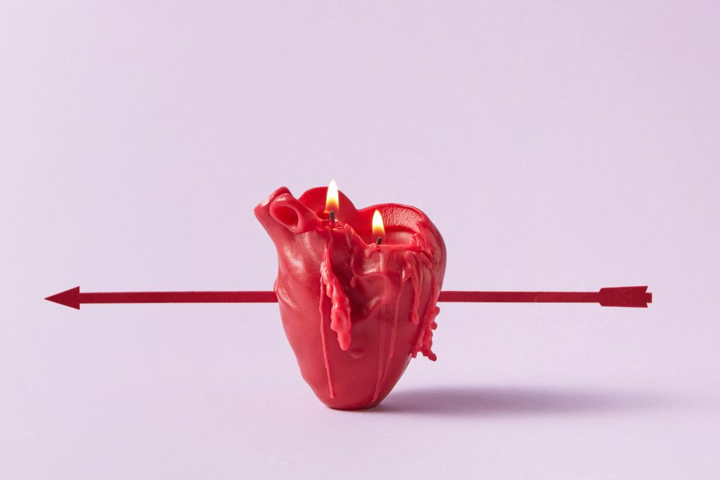 Photo of a Red Heart Candle Pierced by an Arrow
