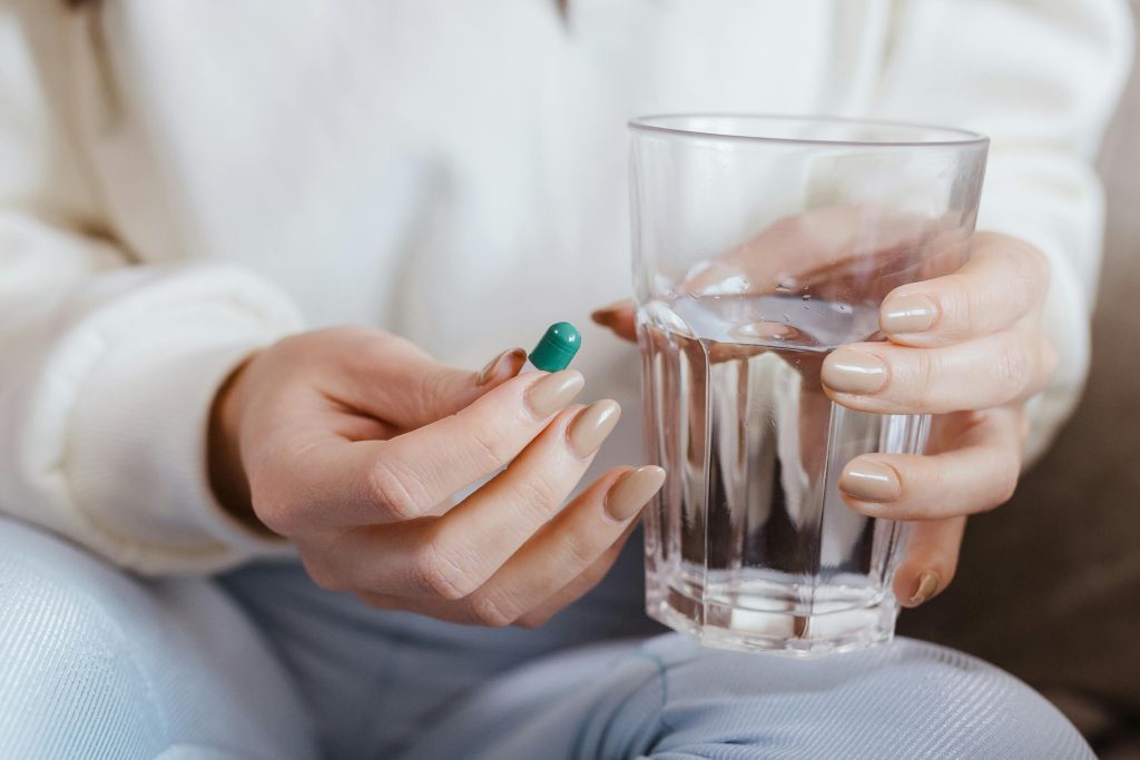 Woman Holding Pill and Glass of Water
