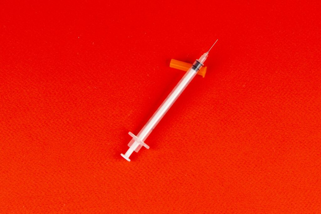 Syringe on a Red Surface
