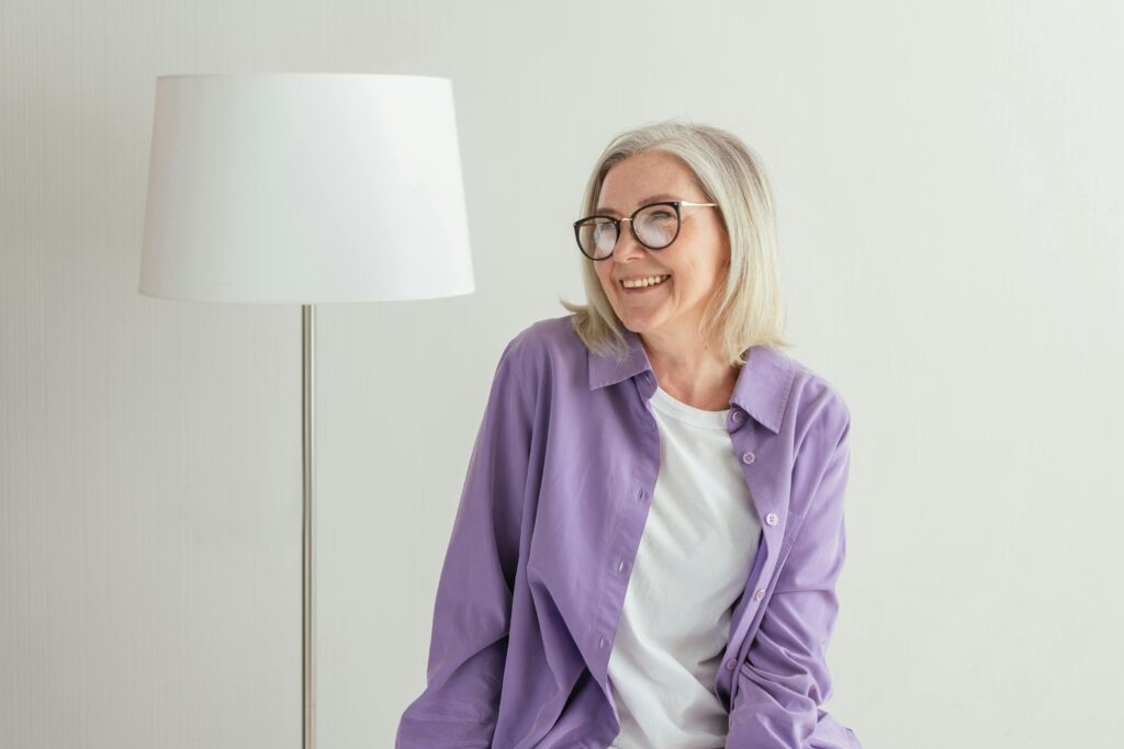 A Woman in Purple Long Sleeves Smiling while Wearing Eyeglasses