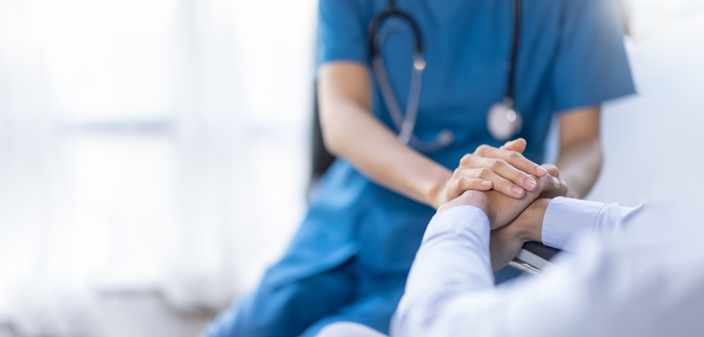 Cropped shot of a female nurse hold her senior patient's hand. Giving Support. Doctor helping old patient with Alzheimer's disease. Female carer holding hands of senior man
