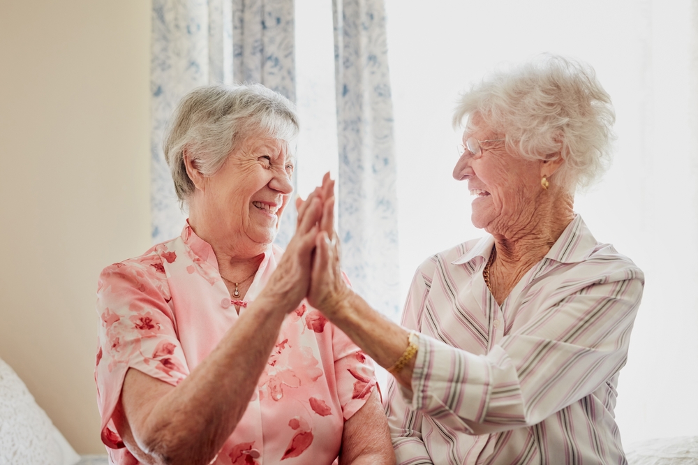 Happy, success and senior women with high five for care, retirement support and happiness. Smile, love and elderly friends with excited gesture for solidarity or community in a nursing home together
