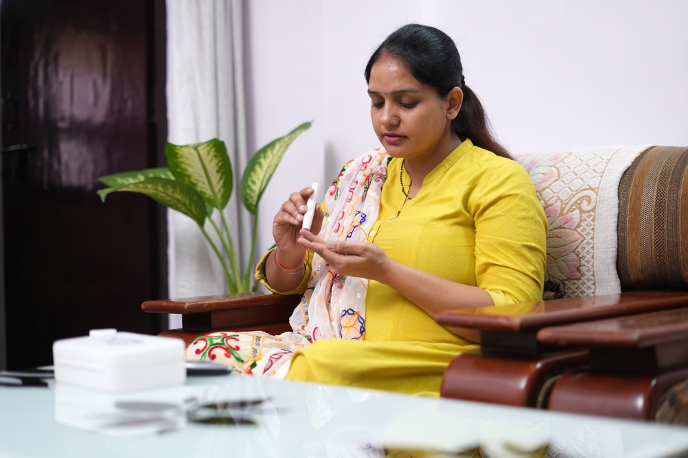 Young Indian women using Glucometer
