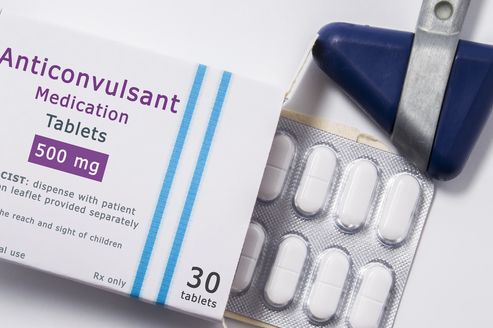 Anticonvulsant drug. Neurological hammer and packaging box of medication with name group of drug Anticonvulsant with blister with pills on white background close up. Concept for treatment of Epilepsy