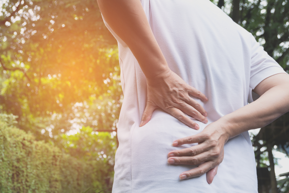 A man suffering from backache, spinal injury and muscle issue problem at outdoor.
