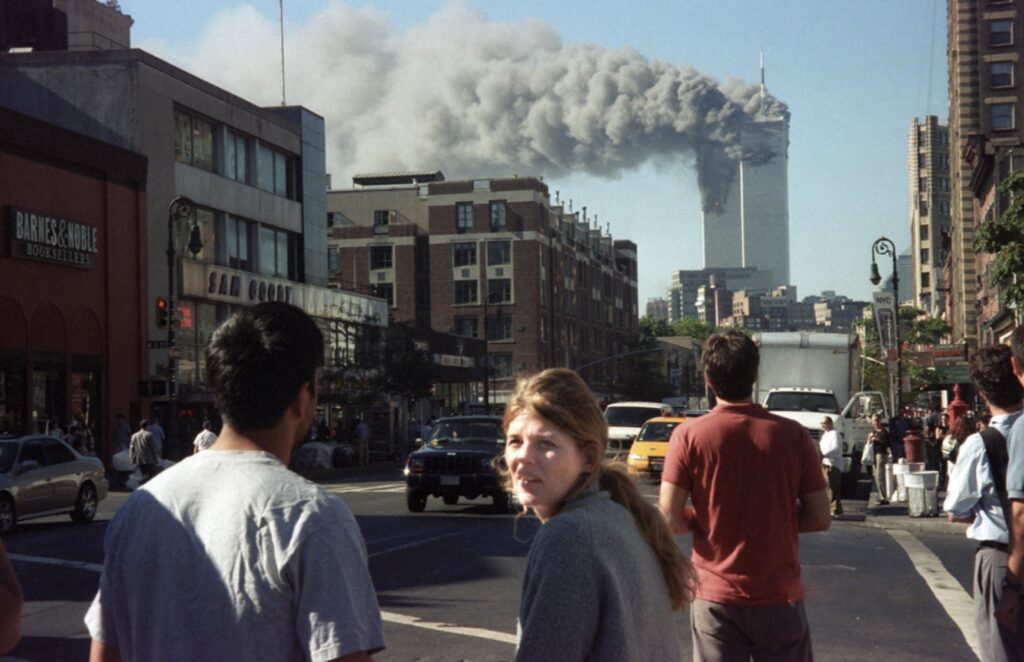 people stare toward the burning towers