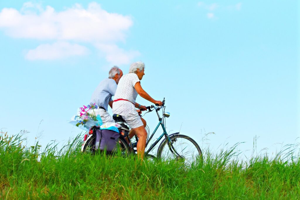 happy elderly couple biking