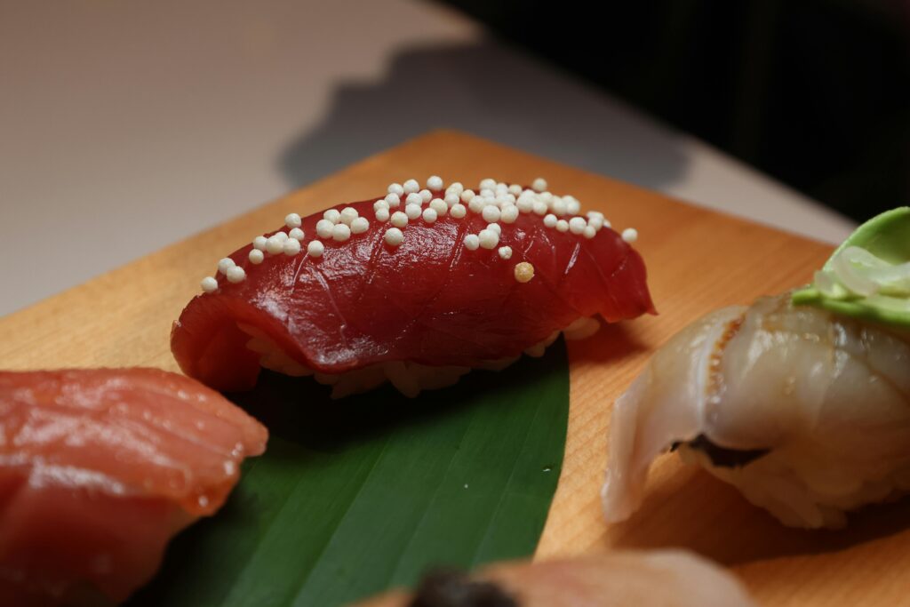 Sushi on a wooden cutting board with sesame seeds
