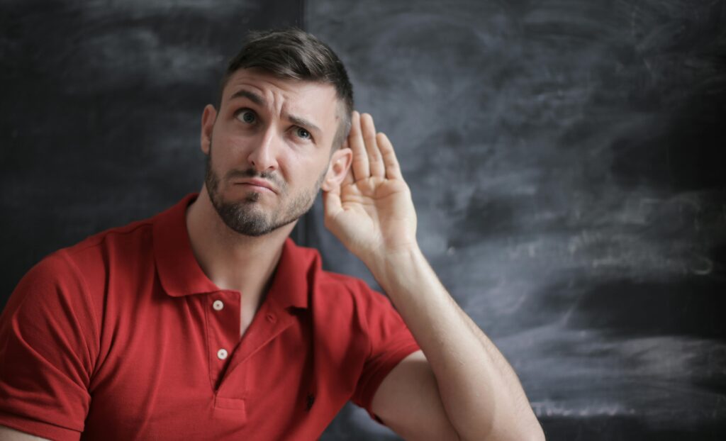 man holding ear, listening