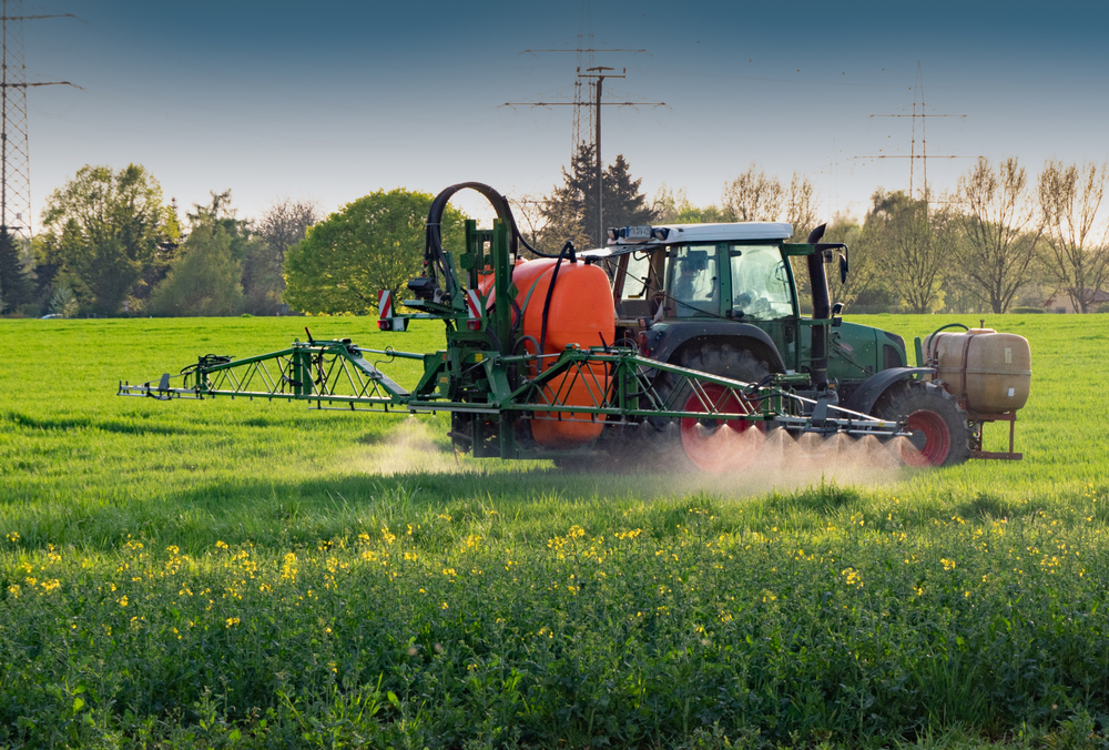 Tractor with sprayer works on a field