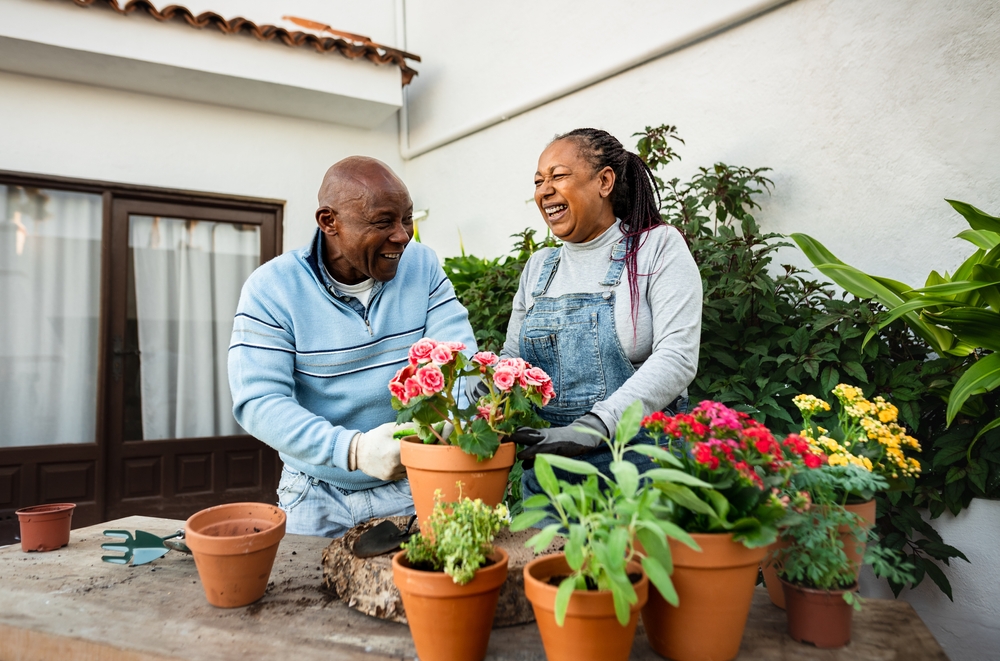 Happy African senior people gardening together at home
