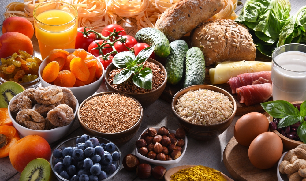 Composition with assorted organic food products on wooden kitchen table.