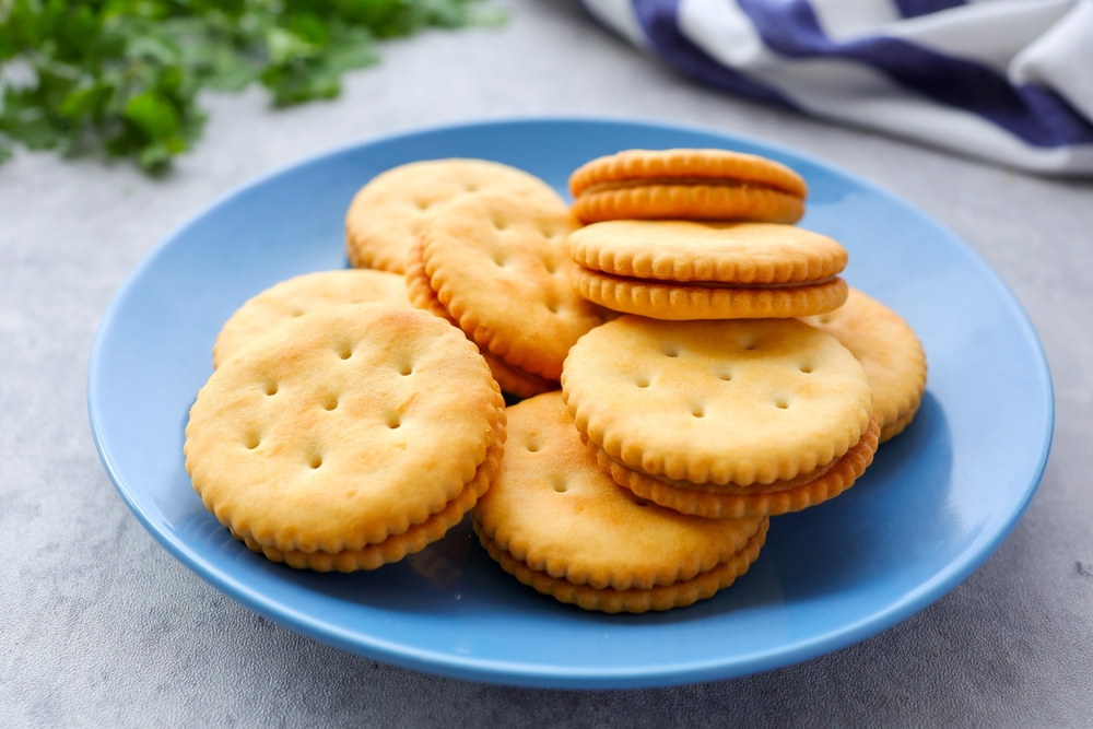 Sandwich cracker peanut butter,cracker in a blue plate on light cement background