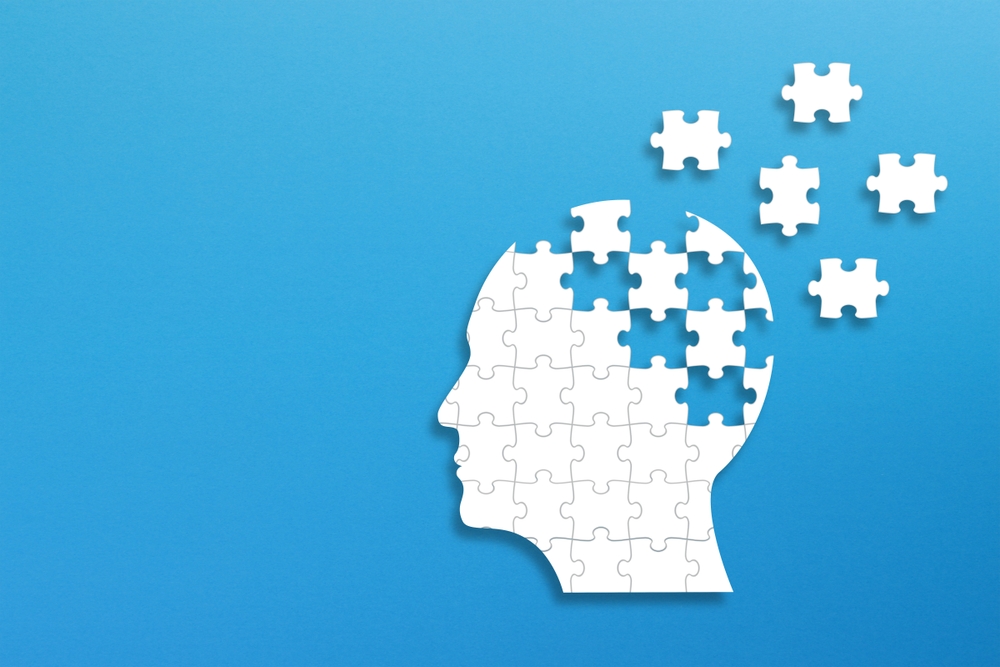 Dementia and parkinson's disease. Head and brain diseases concept. Human head shaped puzzle on blue background.
