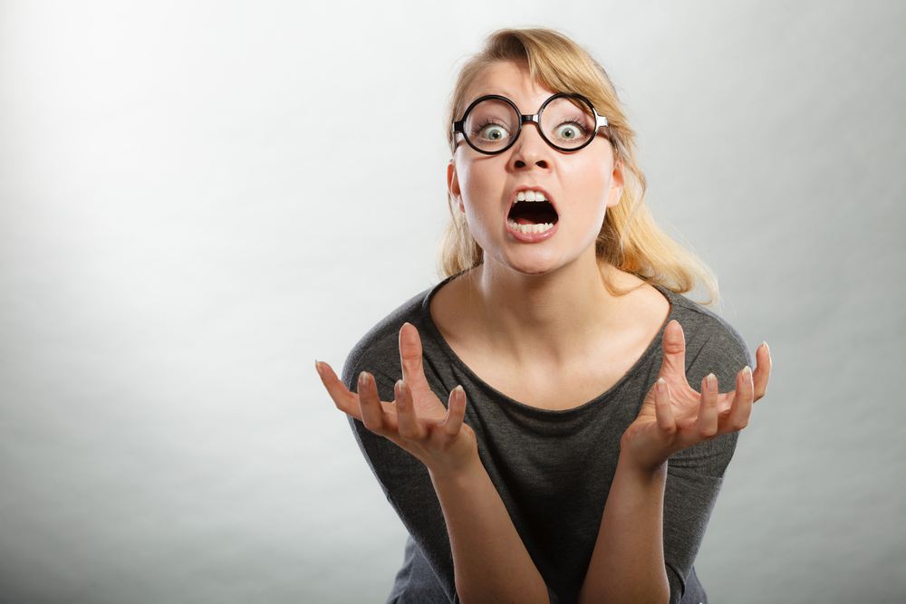 Anger and rage concept. Young expressive woman show her bad face. Angry nervous annoyed girl portrait. Human full of negative emotions.
