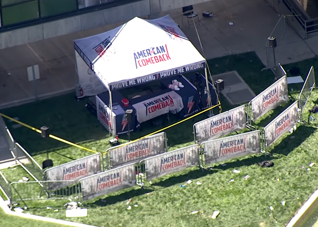 Aerial view of the Utah Valley University campus showing the aftermath of the Charlie Kirk shooting. A white tent with 'American Comeback' branding is visible in the center, surrounded by yellow police tape.