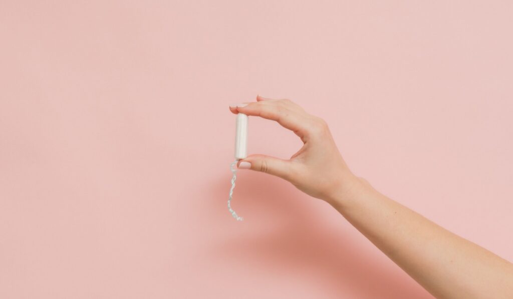 Hand holding a medical feminine tampon. Cotton swab. Menstruation