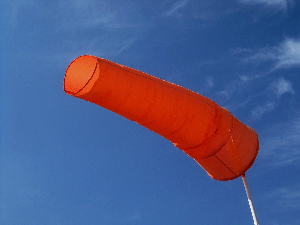 Orange windsock inflated by strong offshore winds that can push swimmers and inflatable toys away from shore.
