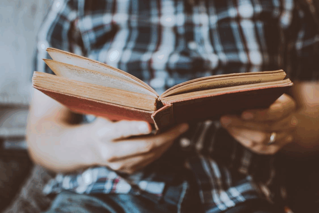 Person Reading Book While Sitting