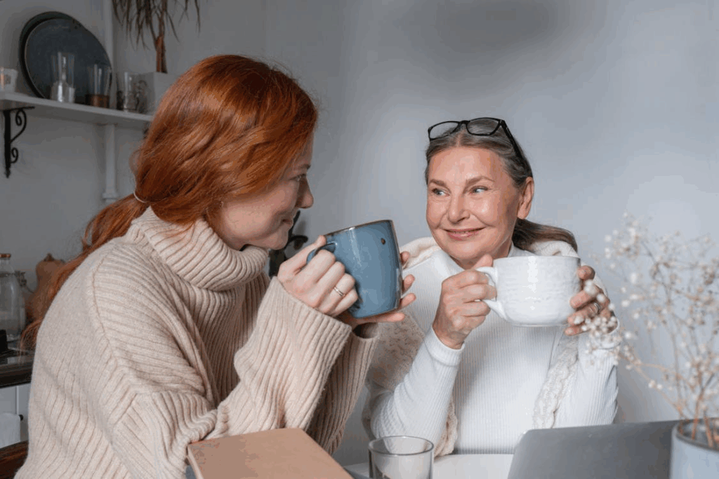 Women Sitting at a Table and Drinking Coffee Together