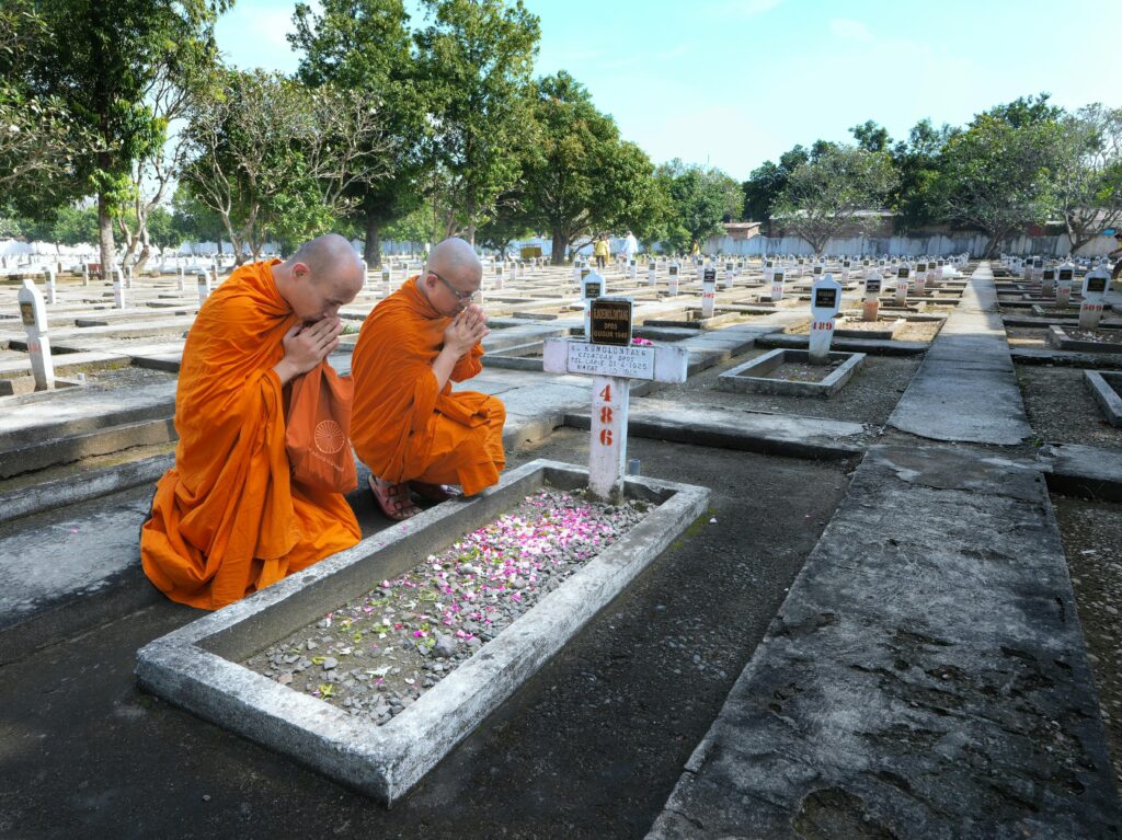 Buddhist Monks Praying at Cemetery in Indonesia
