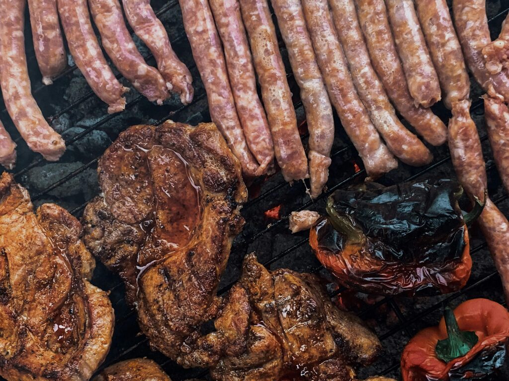 Roasting meat and sausages on barbecue grid