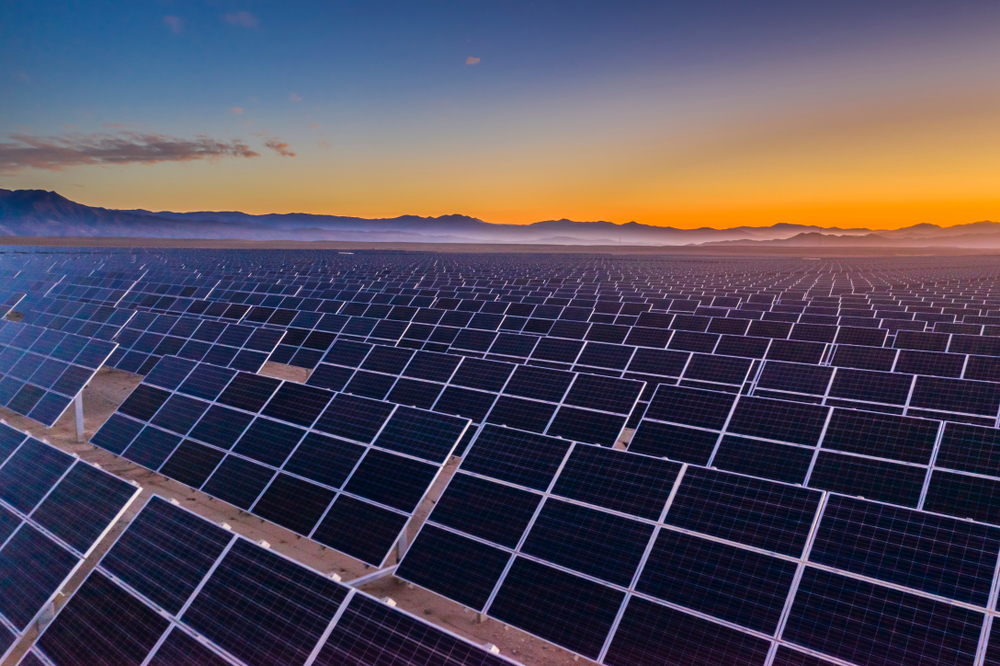 Aerial view of hundreds solar energy panels rows along the dry lands at Atacama Desert, Chile. Huge Photovoltaic PV Plant in the middle of the desert from an aerial drone point of view during sunset