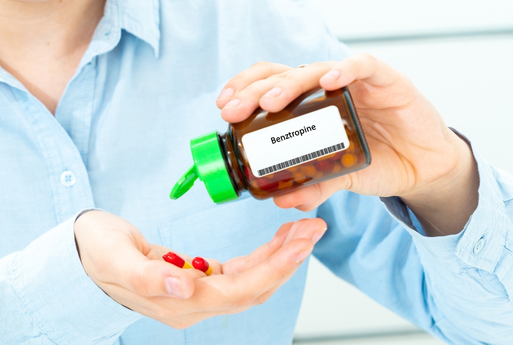 Benztropine Woman Hand holding on open palm with pill tablets medicine for healing
