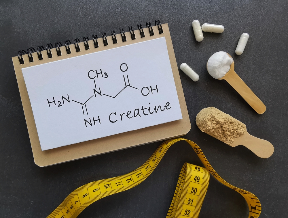 Structural chemical formula of creatine. Creatine is a very popular sports supplement, used to increase muscle mass. Creatine white and brown powder, pills, measuring tape. Sport nutrition concept.
