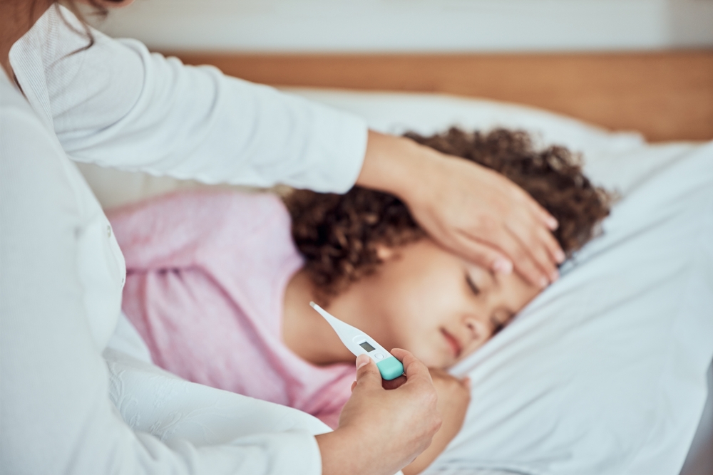 Mom, sick girl and tool for fever in home, virus and monitor temperature for covid infection. Mother, daughter and childcare for cold or flu in bedroom, thermometer and symptoms of sinus bacteria