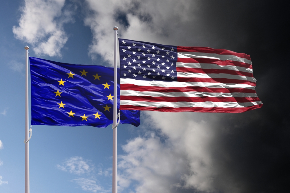EU and USA flags above dark sky. Europe Union and United States of America trade, tariffs and political confrontation