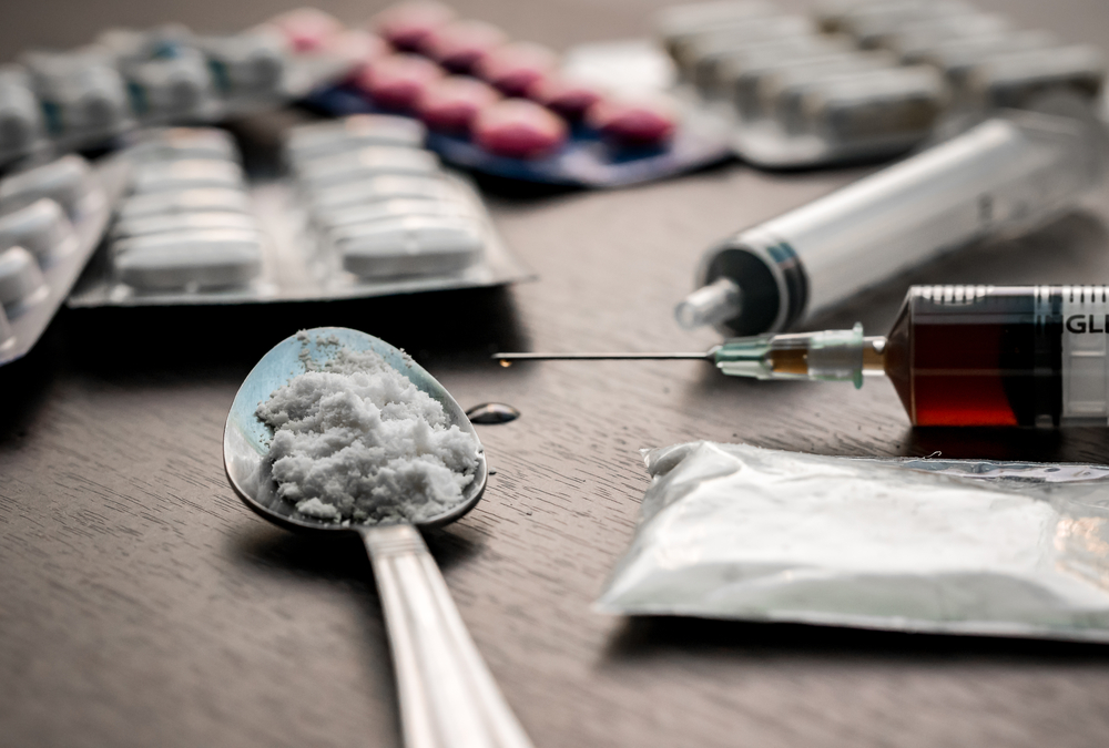 Drug syringe and cooked heroin on spoon