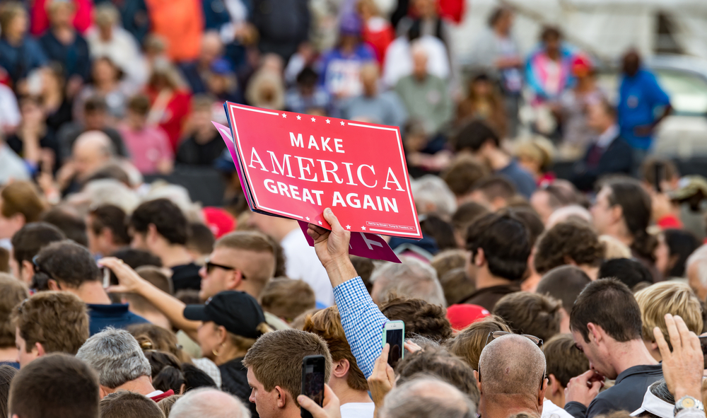 Mobile, Alabama - 12/17/2016:  A Trump supporter holds up a "Make America Great Again" sign in the crowd as US President-elect Donald J. Trump prepares to enter the stage at Ladd-Peebles Stadium.