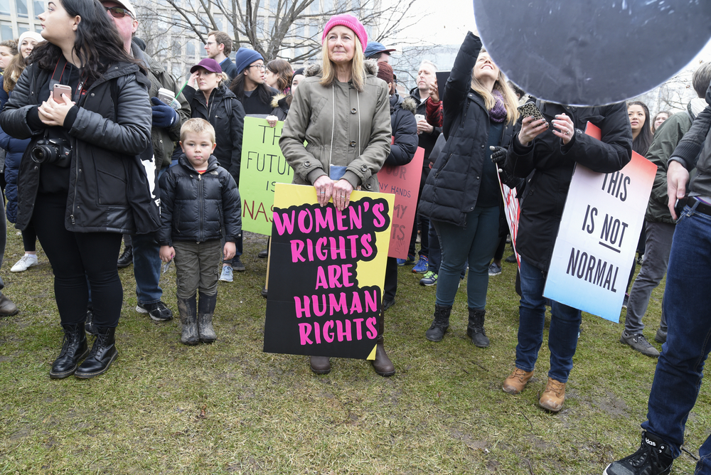 TORONTO-JANUARY 21:An old woman with sign, equaling women's rights as human rights during the "Women's March on Washington" to protest against Trump presidency on January 21, 2017 in Toronto, Canada.